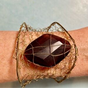 Large purple stone set in gold wire bracelet